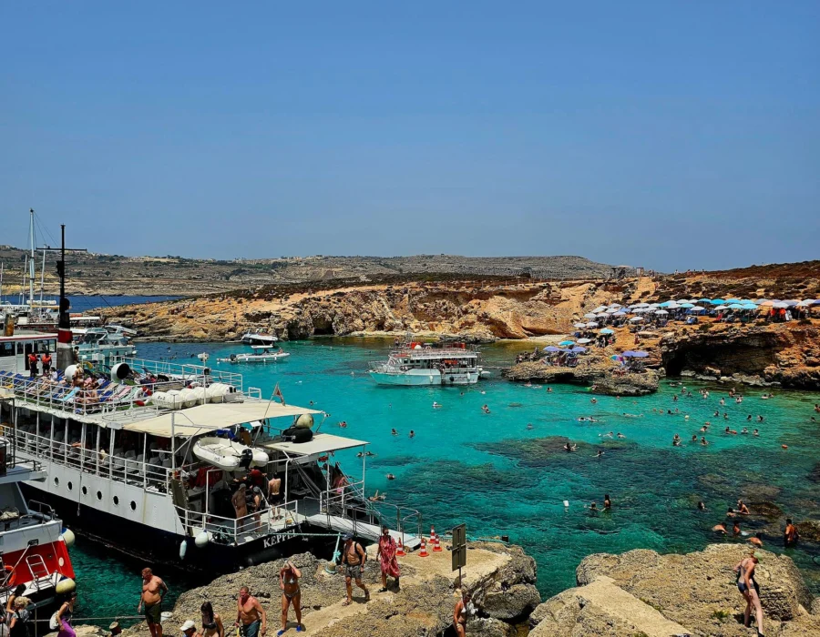 Boats and visitors in the clear water at the Blue Lagoon in Comino