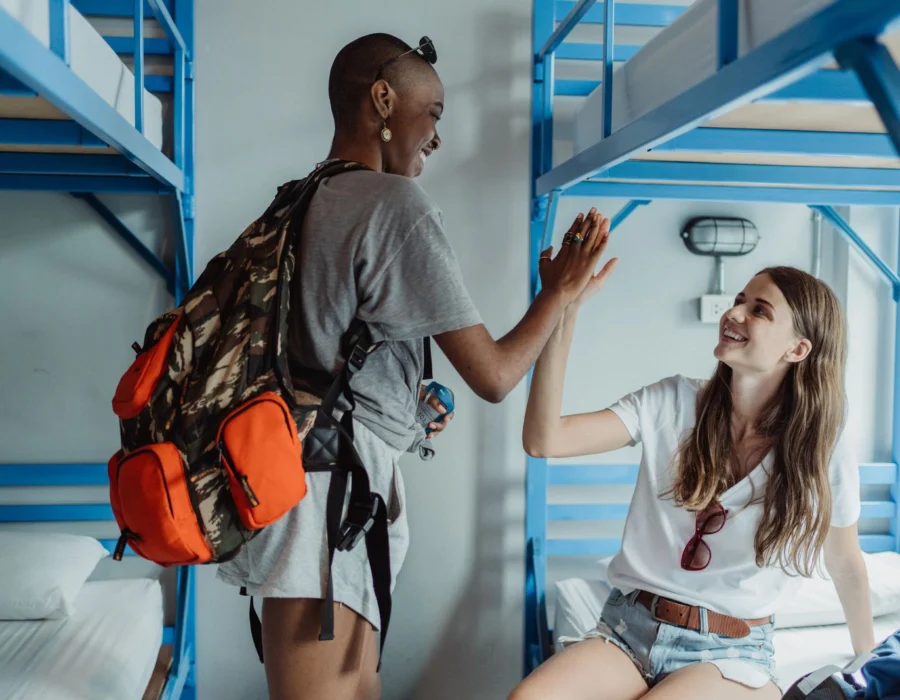 Two travellers in a bright hostel dorm room