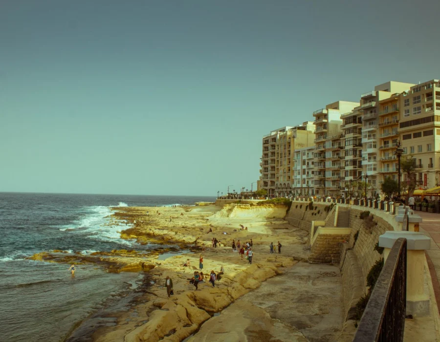 A quiet coastal promenade below apartment buildings