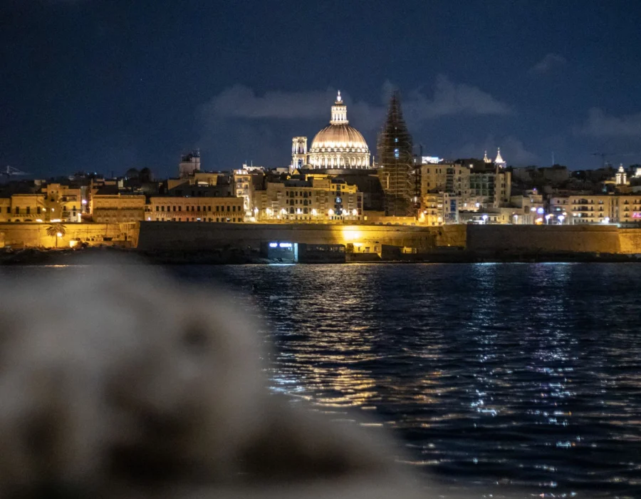 A waterfront city illuminated at night