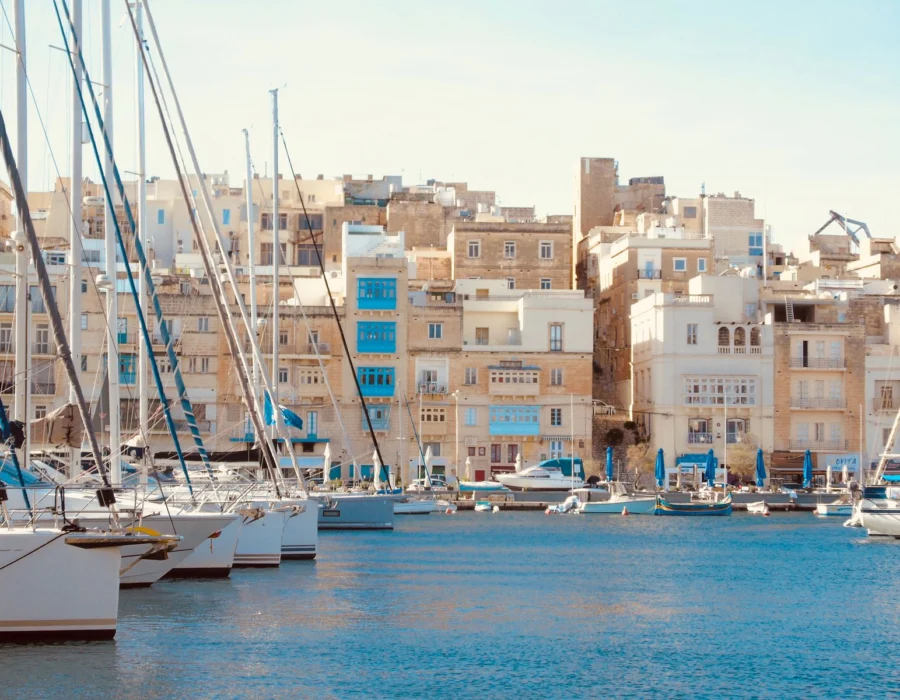 A Mediterranean harbour with sailboats and historic buildings