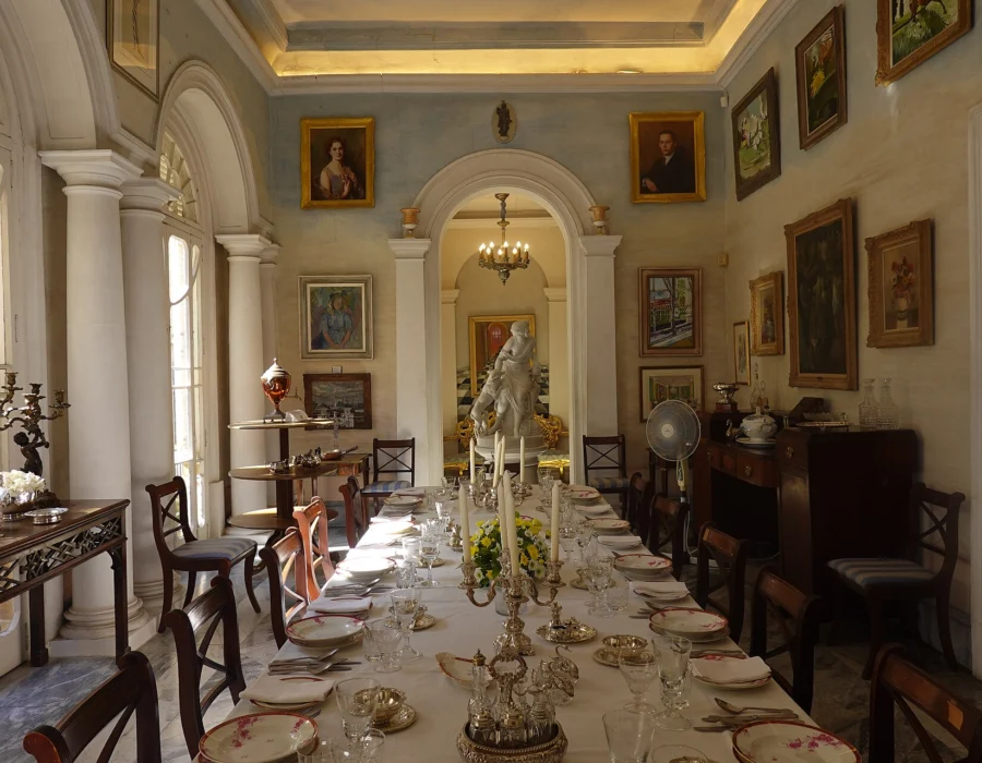 The dining room at Casa Rocca Piccola, the table laid under family portraits