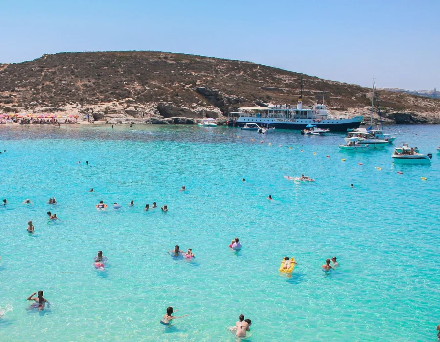 The clear turquoise water and bare limestone coast of Comino