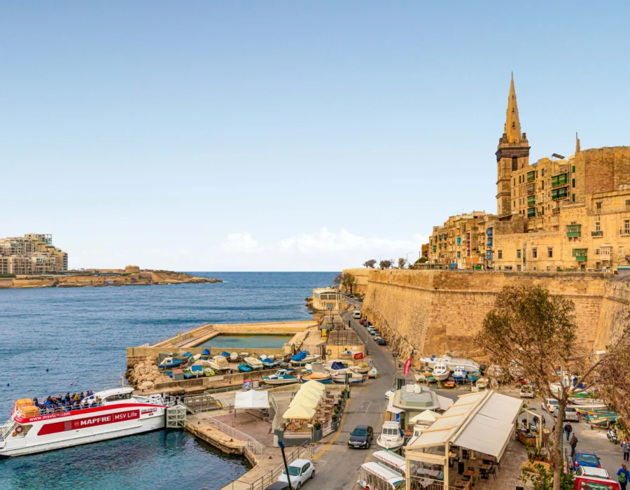 Ferries docked beside a historic fort in the Grand Harbour