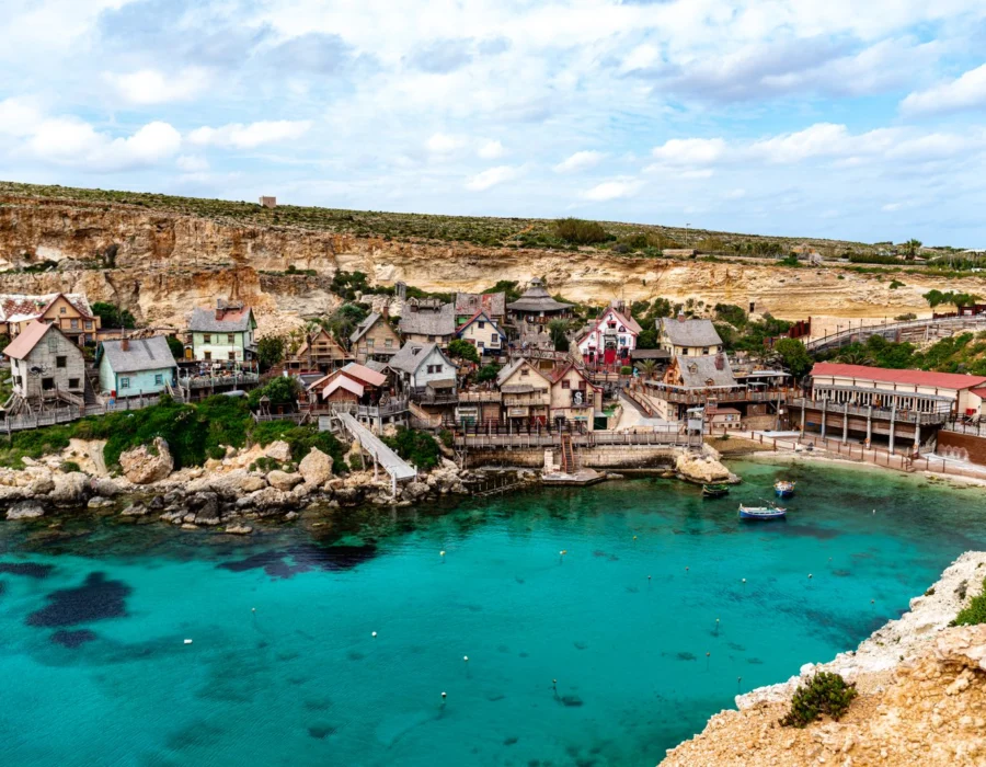 The wooden houses of Popeye Village above the turquoise water at Anchor Bay