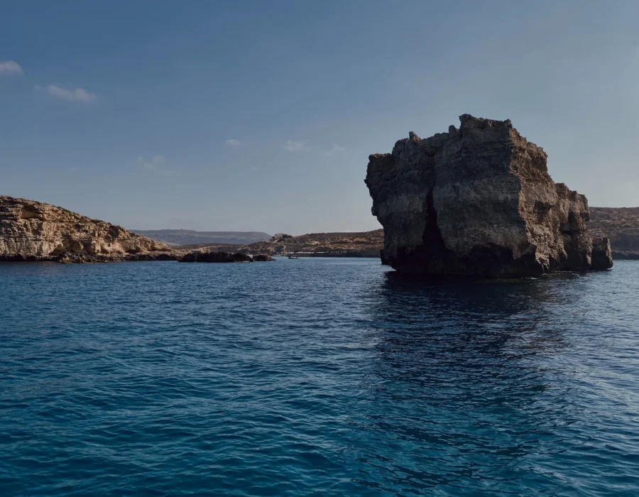 Flat limestone rock running into deep blue water on the Maltese coast