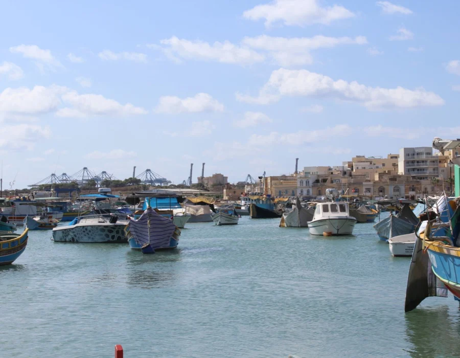 Traditional painted Maltese luzzu fishing boats in Marsaxlokk harbour
