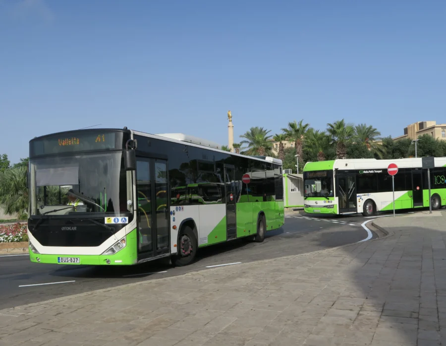 A white and green Malta Public Transport bus leaving Valletta bus station