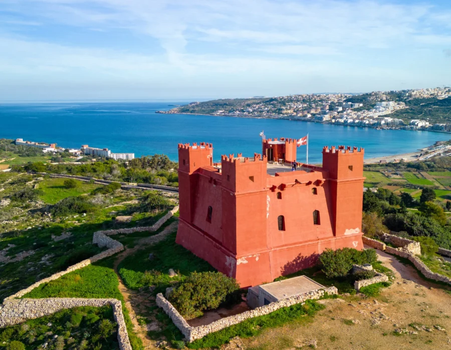 St Agatha's Tower, the red watchtower on Marfa Ridge, with Melliħa behind it