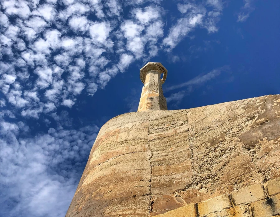 A historic Maltese watchtower against a blue sky