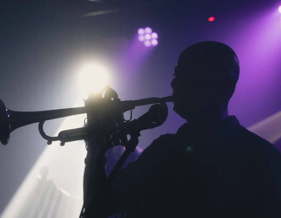 A trumpet player silhouetted at a concert