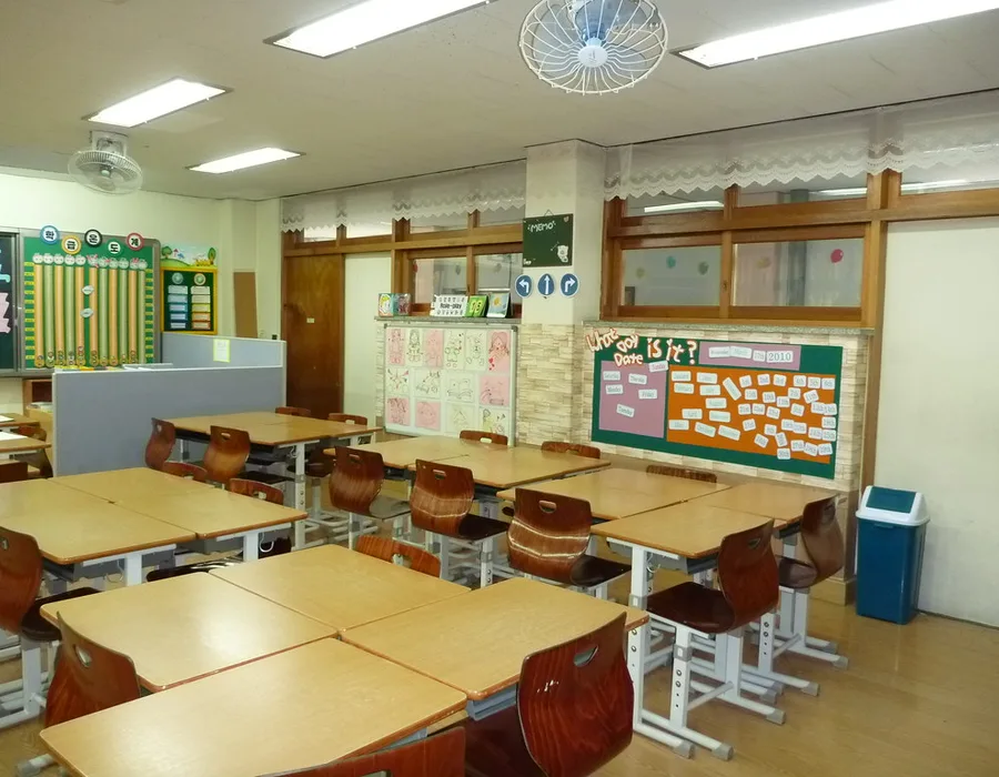 An empty classroom with rows of wooden desks