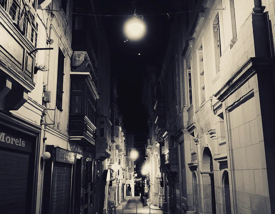 A quiet Valletta side street lit at night