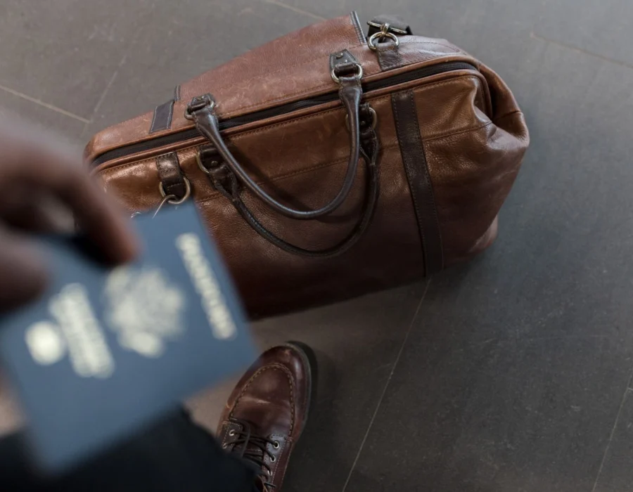 A travel bag and passport in an airport departure hall