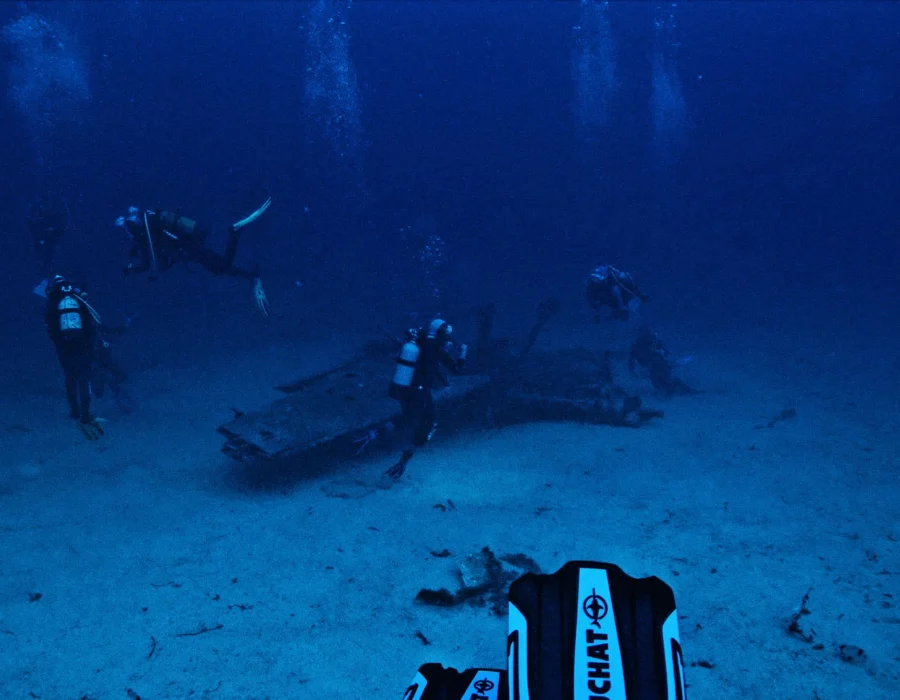 Divers underwater near a wreck