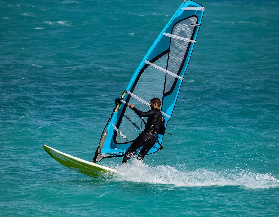 A windsurfer sailing across open water