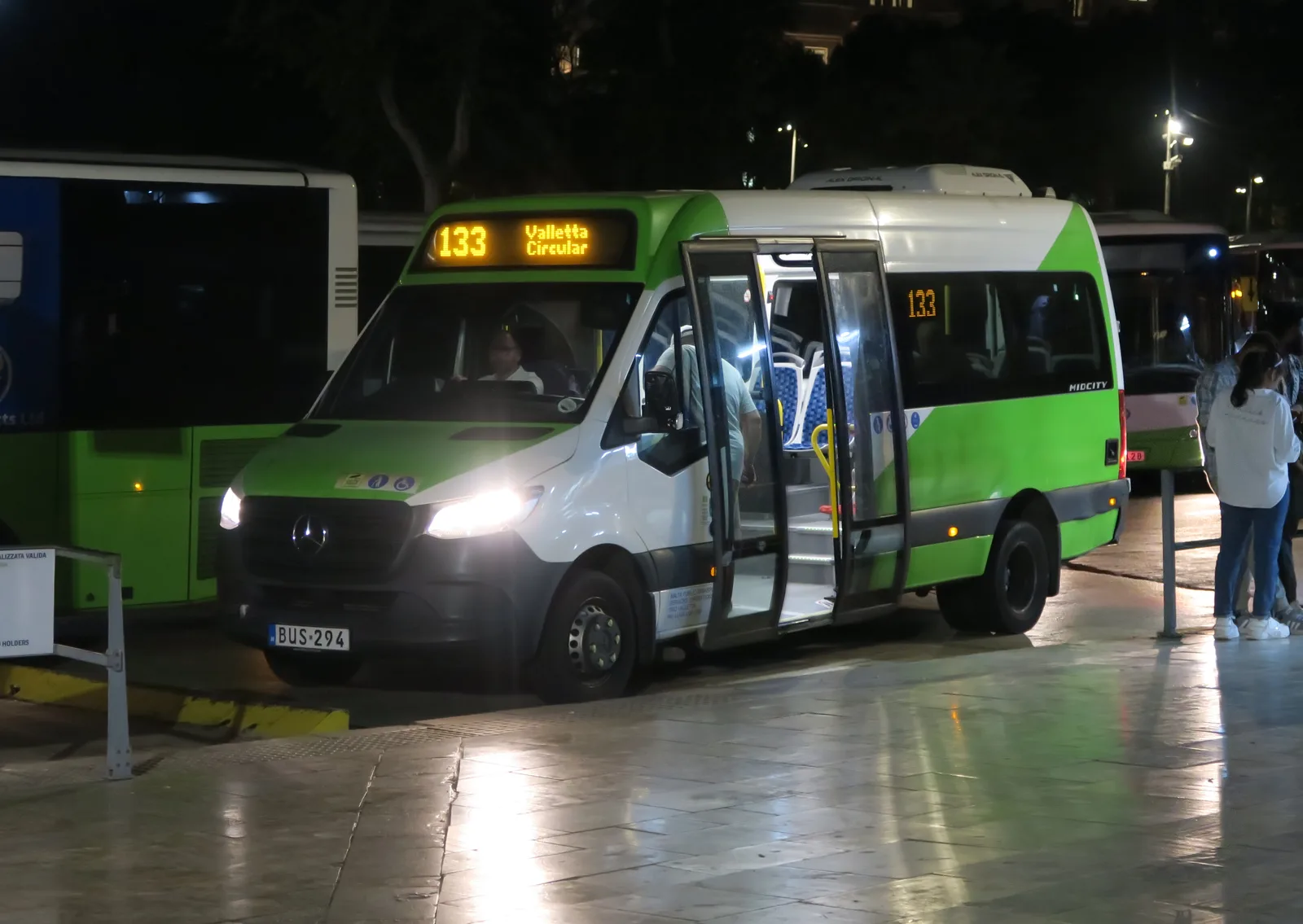 A Malta Public Transport minibus with its doors open at night
