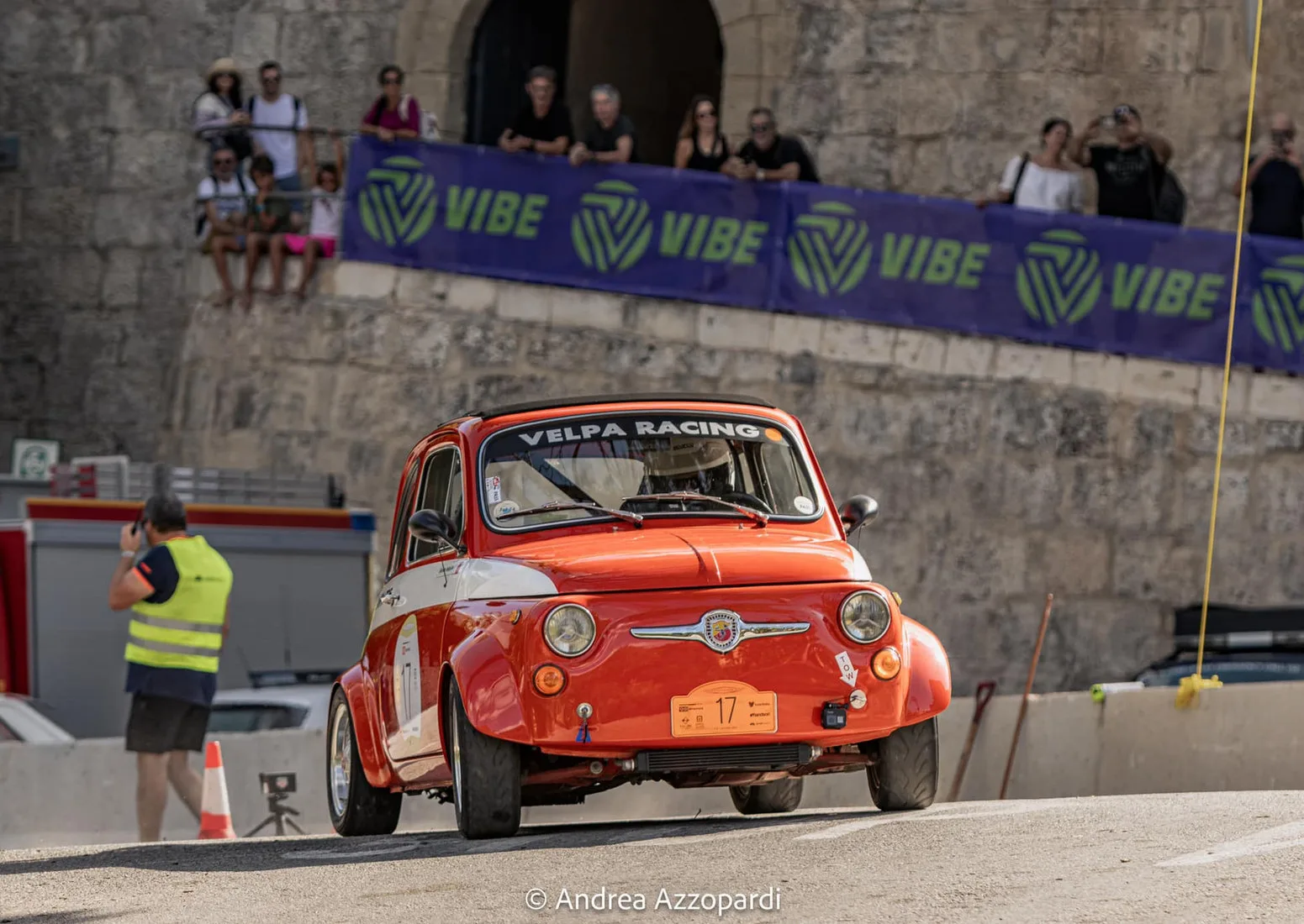 A red Fiat Abarth racing below the Mdina bastions during the Malta Classic